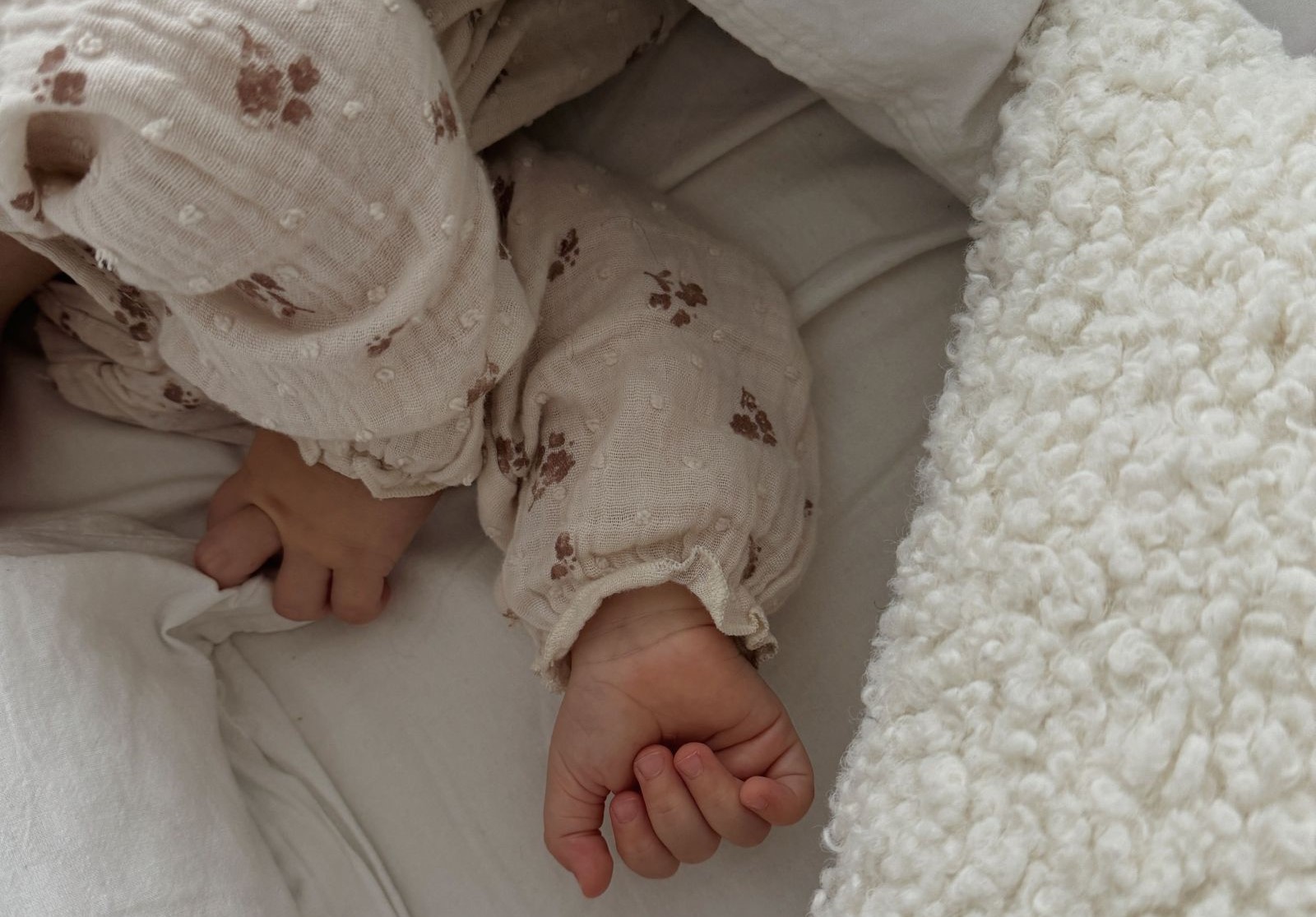 Baby schläft unter Decke. Baby-Hände sichtbar